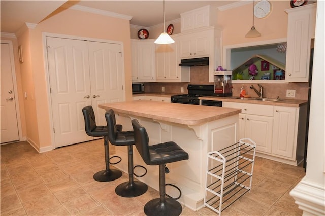 kitchen featuring sink, white cabinetry, hanging light fixtures, a center island, and black appliances