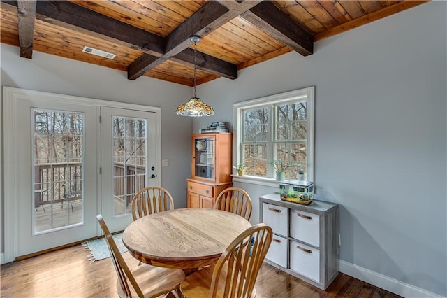 dining room featuring beam ceiling, a wealth of natural light, wood ceiling, and light hardwood / wood-style flooring