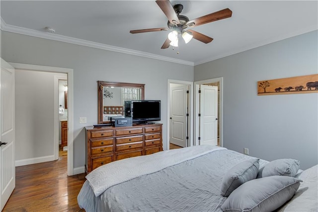 bedroom with crown molding, ceiling fan, ensuite bathroom, and dark hardwood / wood-style flooring