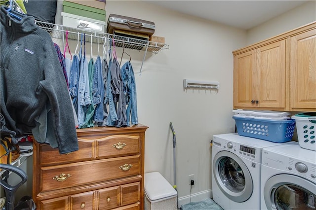 clothes washing area featuring cabinets and washer and dryer