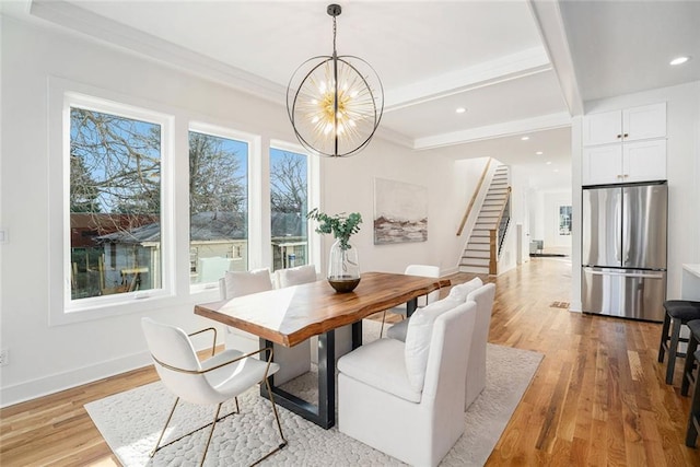 dining area with light hardwood / wood-style floors, beamed ceiling, a chandelier, and a healthy amount of sunlight