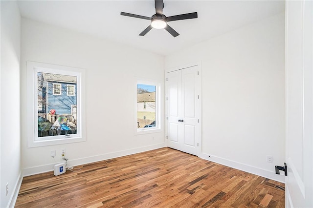 unfurnished room with hardwood / wood-style flooring, a wealth of natural light, and ceiling fan