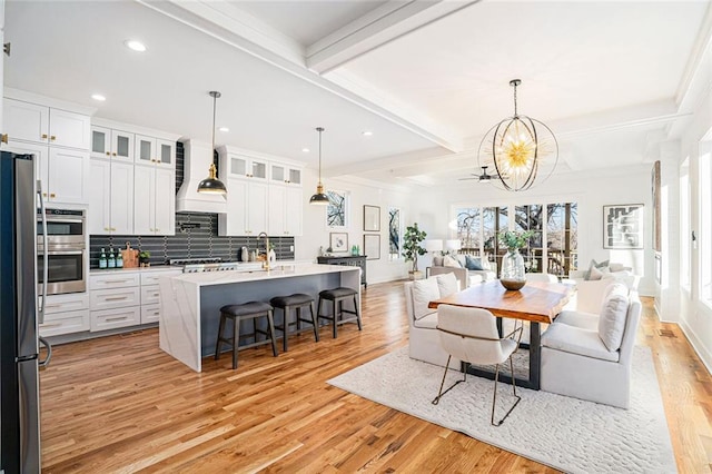 interior space with white cabinetry, beamed ceiling, and tasteful backsplash