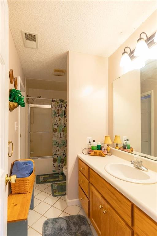 full bathroom featuring tile patterned flooring, a textured ceiling, shower / tub combo with curtain, vanity, and toilet