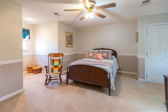 carpeted bedroom featuring a textured ceiling and ceiling fan