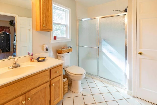 bathroom with walk in shower, vanity, toilet, and tile patterned flooring