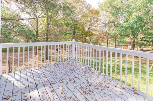 wooden terrace featuring a lawn