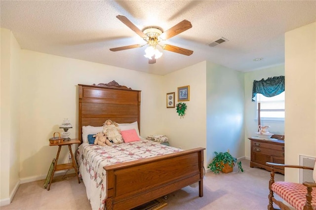 bedroom with a textured ceiling, light carpet, and ceiling fan