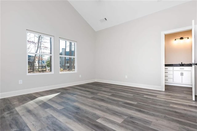 unfurnished bedroom with lofted ceiling and dark wood-type flooring