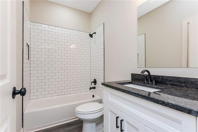 full bathroom featuring tiled shower / bath, vanity, toilet, and wood-type flooring