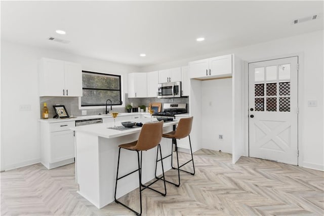 1066 Cleavemark Dr, Clarkston, GA 30021 - kitchen featuring stainless steel appliances, a kitchen breakfast bar, light countertops, white cabinets, and recessed lighting
