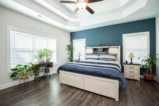 bedroom with multiple windows, dark hardwood / wood-style flooring, and ceiling fan