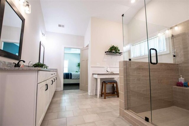 bathroom featuring tile patterned floors, walk in shower, and vanity