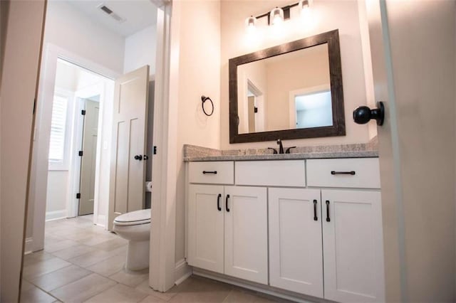 bathroom with vanity, toilet, and tile patterned floors