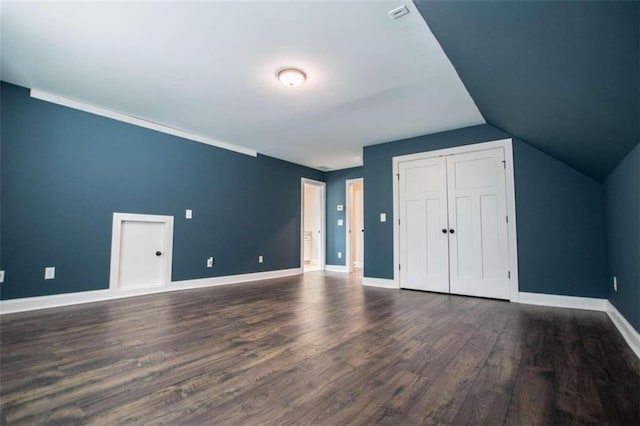 additional living space featuring vaulted ceiling and dark hardwood / wood-style flooring