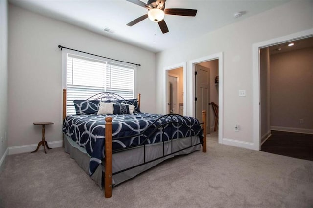 carpeted bedroom featuring ensuite bath and ceiling fan