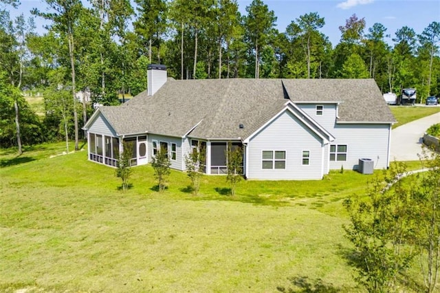 back of property with central AC, a lawn, and a sunroom