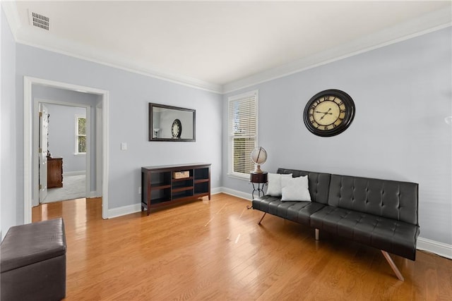 living room with light hardwood / wood-style floors and ornamental molding