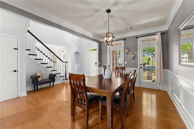 dining room featuring a chandelier, wood-type flooring, and ornamental molding