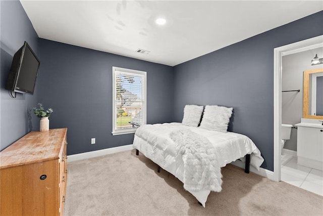 bedroom with light carpet and connected bathroom