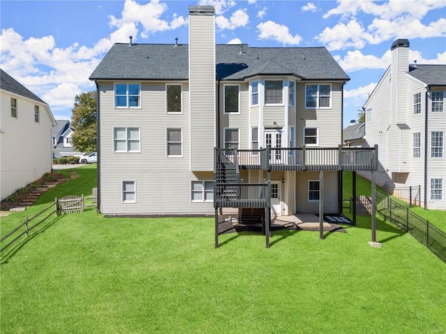 rear view of property featuring a patio area, a deck, and a yard