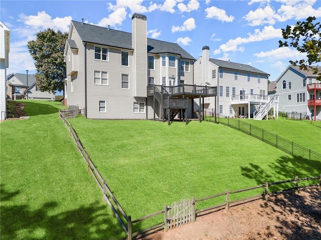 rear view of house featuring a deck and a lawn