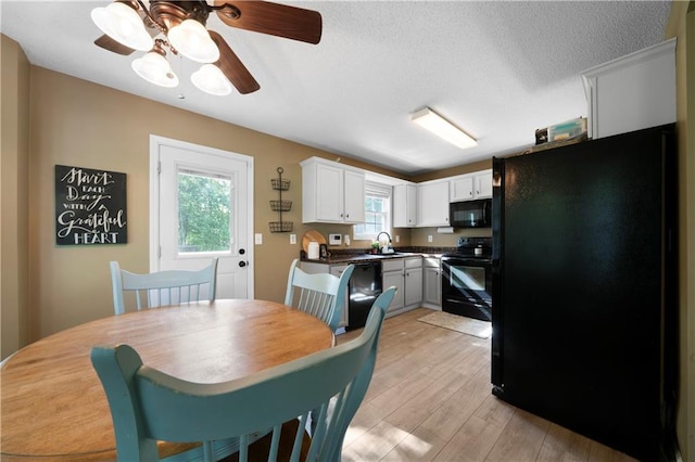 71 Headland Ct, Rockmart, GA 30153 - kitchen featuring black appliances, light wood finished floors, ceiling fan, white cabinets, and dark countertops