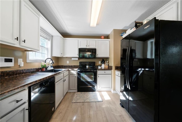 71 Headland Ct, Rockmart, GA 30153 - kitchen featuring black appliances, a sink, light wood-type flooring, dark countertops, and white cabinets