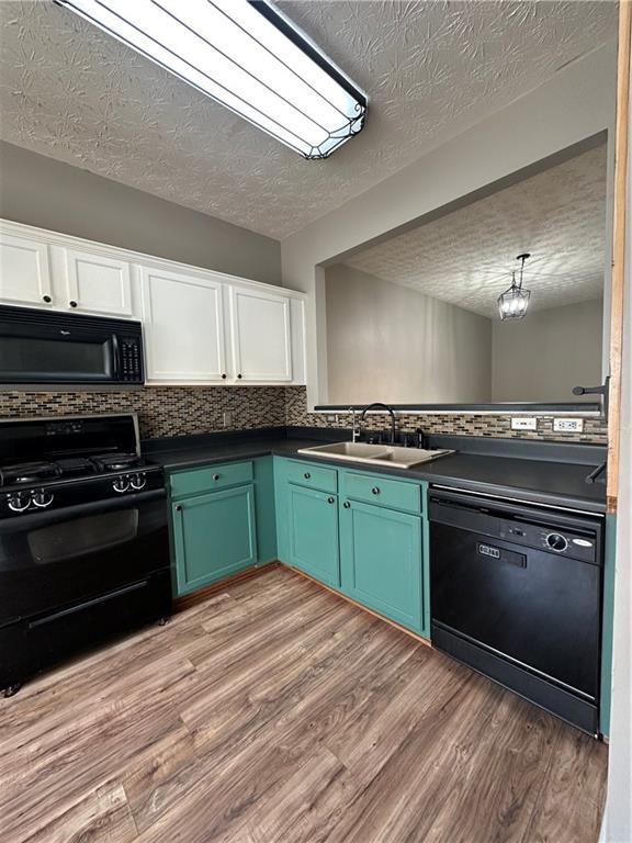 kitchen with white cabinetry, sink, light hardwood / wood-style flooring, and black appliances