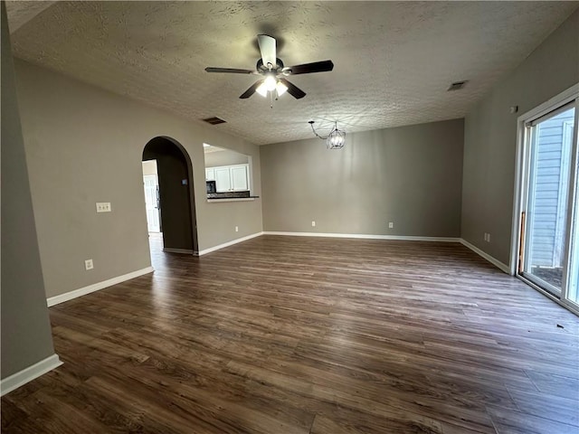 unfurnished living room featuring plenty of natural light, a textured ceiling, and dark hardwood / wood-style flooring