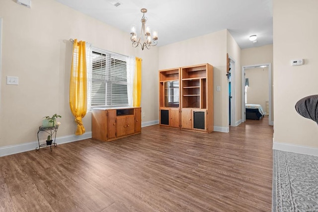 unfurnished living room with a chandelier and hardwood / wood-style flooring