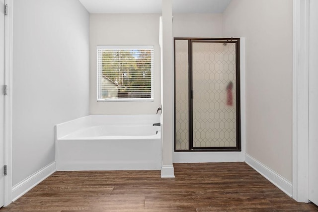 bathroom with wood-type flooring and shower with separate bathtub