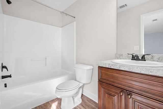 full bathroom with hardwood / wood-style floors, vanity, toilet, and washtub / shower combination