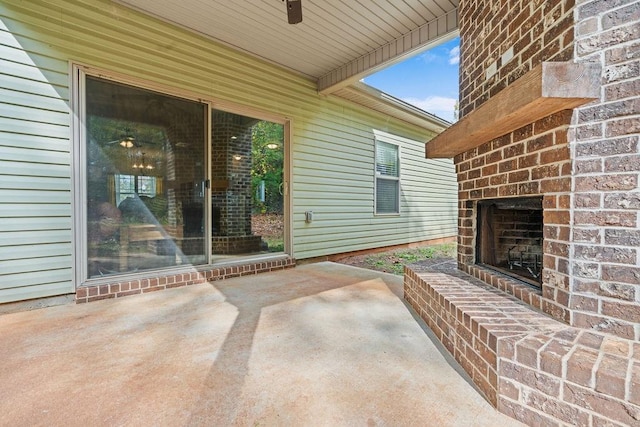 view of patio with ceiling fan and an outdoor brick fireplace