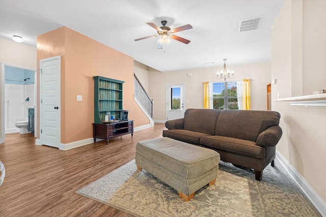 living room with hardwood / wood-style floors and ceiling fan with notable chandelier