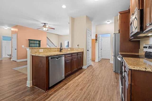 kitchen featuring ceiling fan, light hardwood / wood-style flooring, stainless steel appliances, and sink