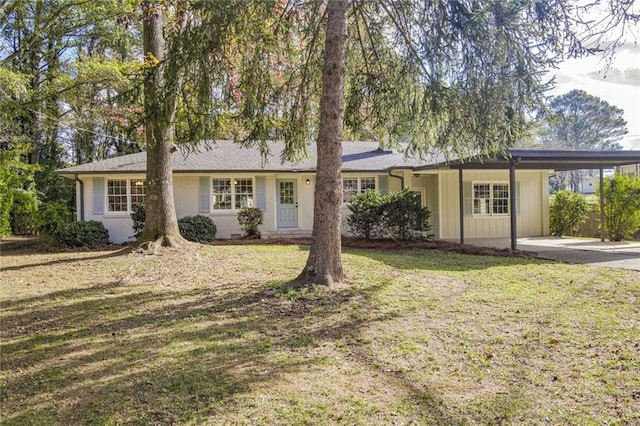 ranch-style house featuring a carport and a front lawn