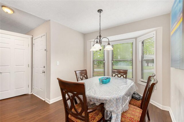 dining area featuring baseboards, a textured ceiling, and dark wood finished floors