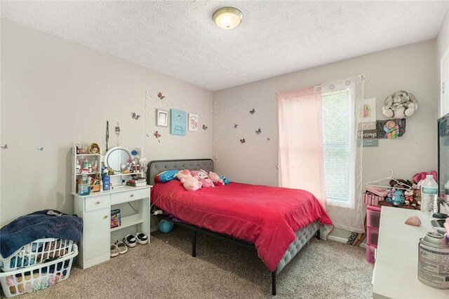 bedroom featuring carpet floors, multiple windows, and a textured ceiling