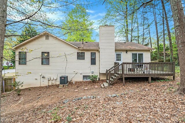 back of property featuring a chimney, central AC, and a deck