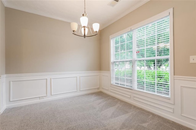 unfurnished room with a chandelier, carpet flooring, crown molding, a wainscoted wall, and a decorative wall