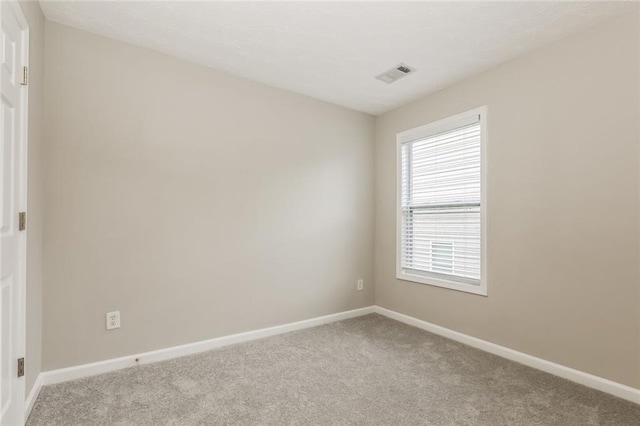 carpeted empty room featuring baseboards