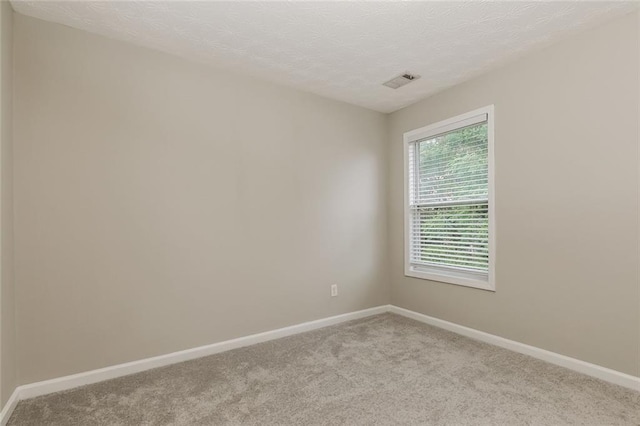 carpeted spare room with baseboards and a textured ceiling