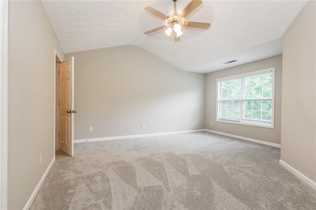 carpeted spare room with ceiling fan, baseboards, and vaulted ceiling