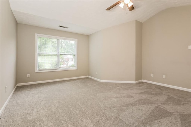 empty room featuring carpet flooring, a ceiling fan, baseboards, and lofted ceiling