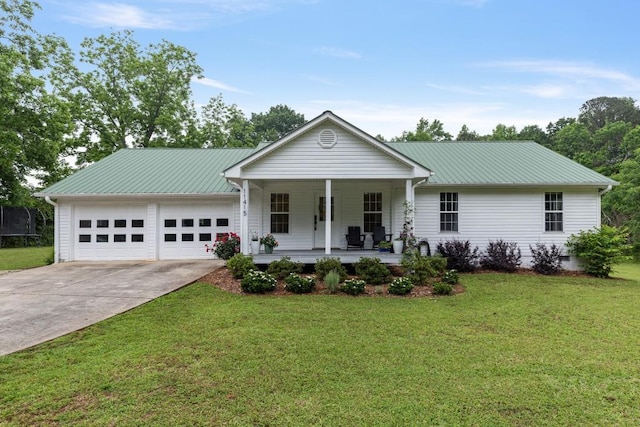 ranch-style house with covered porch, an attached garage, driveway, a front lawn, and a trampoline