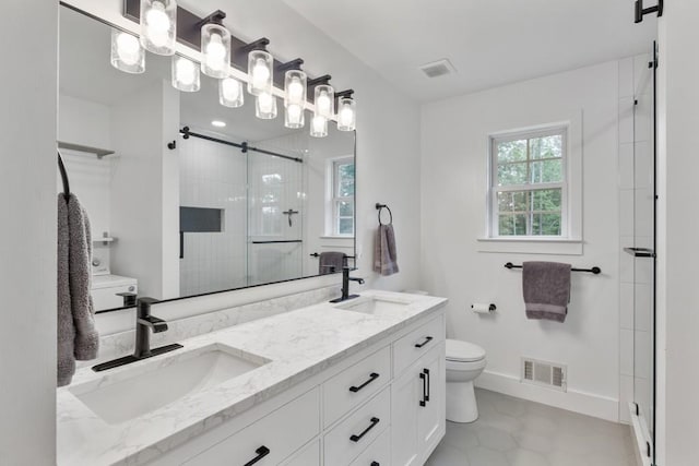 full bath with toilet, a shower stall, double vanity, and baseboards