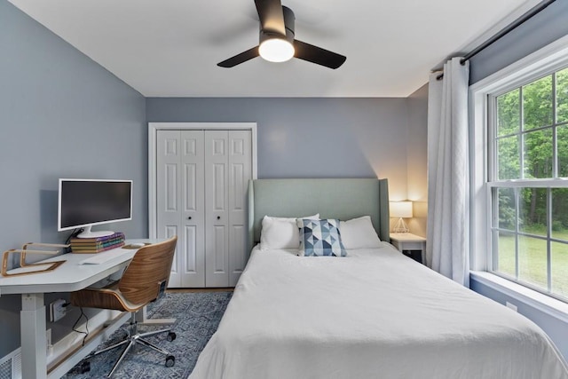 bedroom featuring multiple windows, a closet, ceiling fan, and a desk