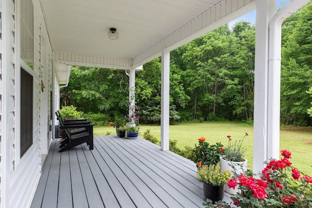 wooden deck with a lawn and a porch