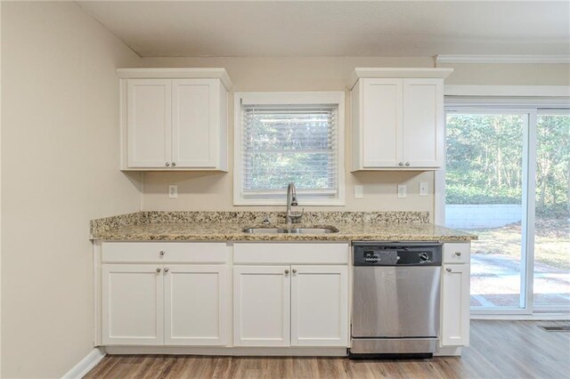 kitchen featuring dishwasher, sink, light hardwood / wood-style flooring, white cabinets, and light stone counters